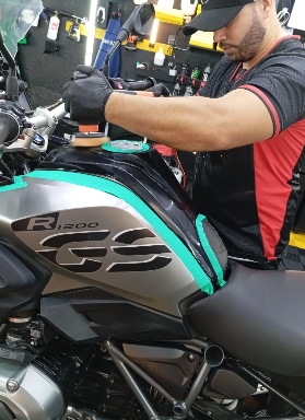 Profissional da Space Car aplicando proteção com todo cuidado e dedicação em uma moto BMW GS