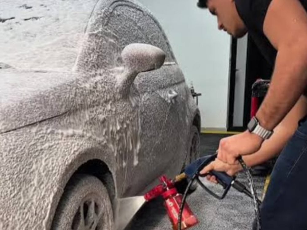 Profissional da Space Car aplicando espuma de lavagem técnica em veículo